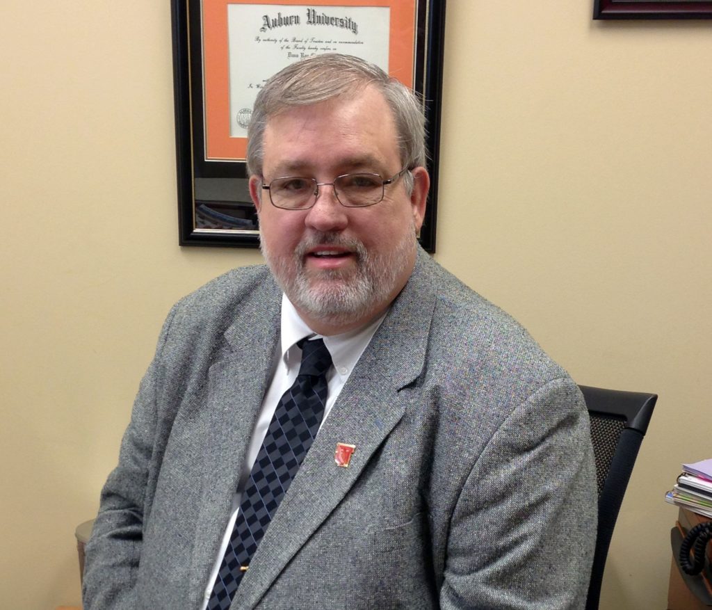 A man in a suit poses for a photo