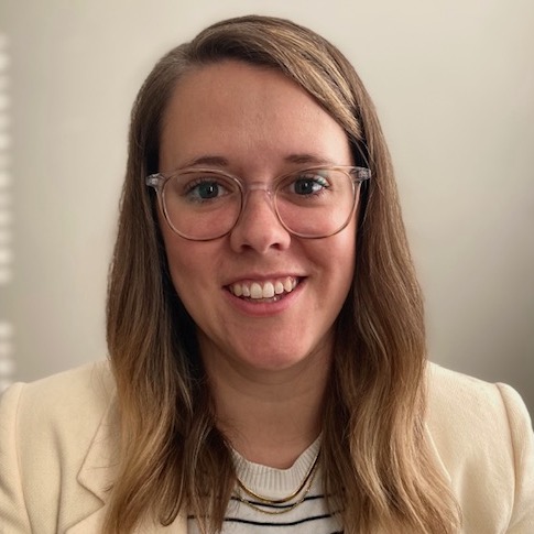 Color headshot photo of Larsen in ivory jacket and striped shirt.