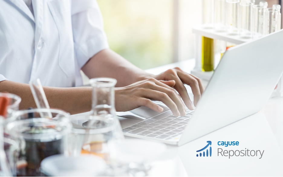 Cayuse Repository promotional image: pair of hands typing on a laptop on a table surrounded by flasks, beakers, and other scientific equipment. 