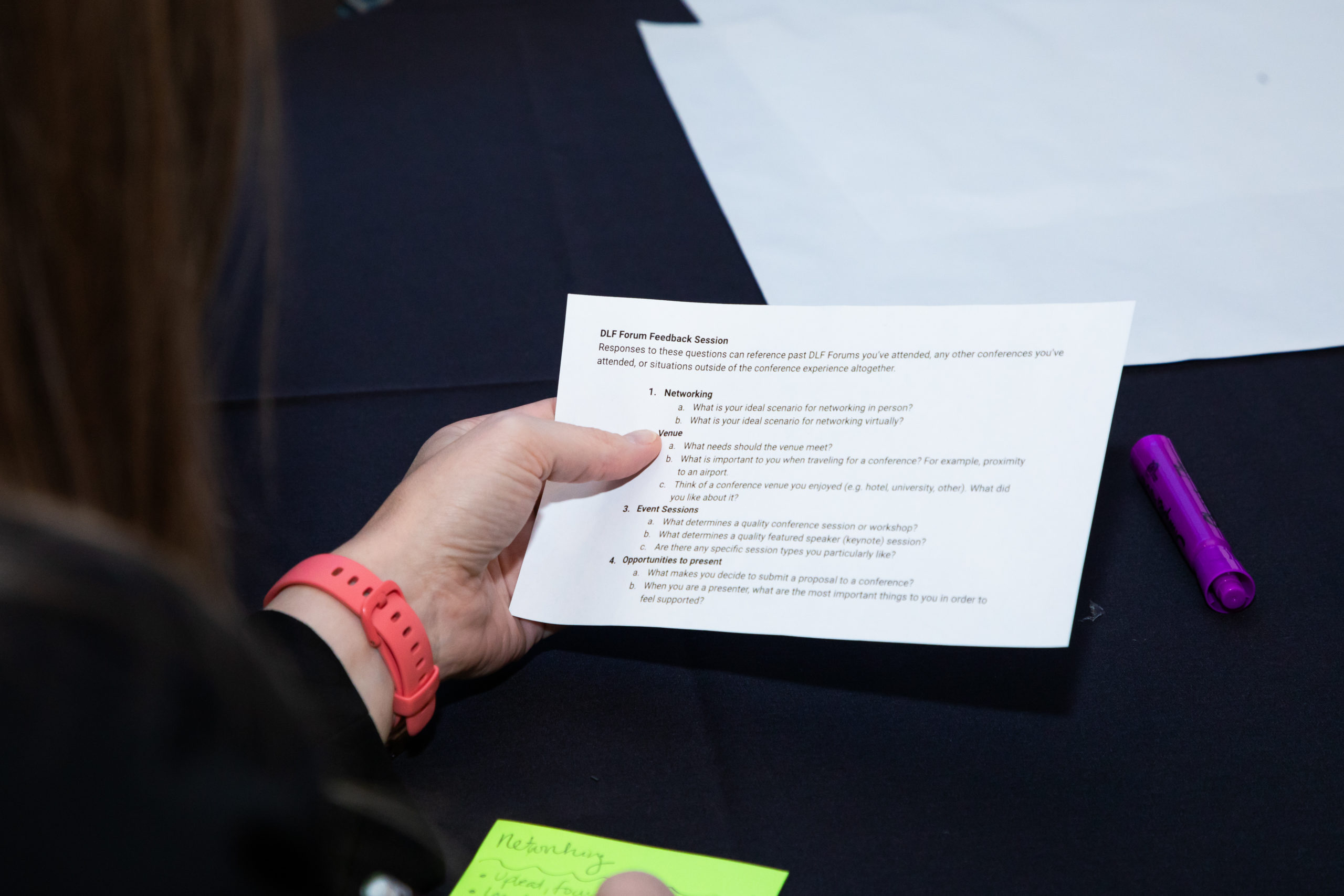 Tight view of someone holding a half sheet of paper with questions.