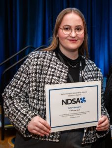 Photo of Sophia von Hoek holding the NDSA award certificate